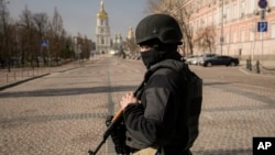 ទាហាន​អ៊ុយក្រែន​ម្នាក់ ឈរ​នៅ​កន្លែង​ត្រួត​ពិនិត្យ​ក្នុង​ទីក្រុង​កៀវ ប្រទេស​អ៊ុយក្រែន នៅថ្ងៃទី២៤ ខែមីនា ឆ្នាំ២០២២។