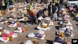 FILE - Afghan workers prepare food supplies during a humanitarian aid campaign for poor families, in Kabul, Afghanistan, Feb. 16, 2022. 