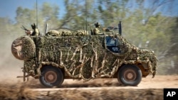 FILE - In this photo provided by the Australian Defense Force, an Australian Army Bushmaster armored vehicle moves off road during a training mission July 7, 2021, in Townsville, Australia. 
