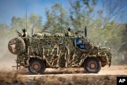 FILE - In this photo provided by the Australian Defense Force, an Australian Army Bushmaster armored vehicle moves off road during a training mission July 7, 2021, in Townsville, Australia.
