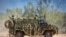 FILE - In this photo provided by the Australian Defense Force, an Australian Army Bushmaster armored vehicle moves off road during a training mission July 7, 2021, in Townsville, Australia. 