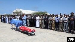 Political leaders pray in front the two bodies of the local lawmakers including Amina Mohamed Abdi after being airlifted from Beledweyne, at Aden Adde International Airport in Mogadishu, Somalia, on March 24, 2022.