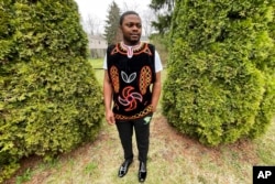 Wilfred Tebah, who fled Cameroon during its ongoing conflict, poses for a photo in the backyard of his home, in Columbus, Ohio, March 31, 2022.