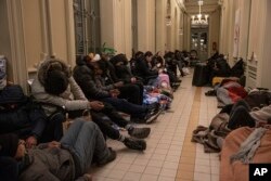 FILE - Refugees sleep at night at the train station in Przemysl, Poland, March 2, 2022.