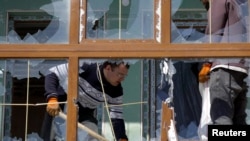 21일 우크라이나 남서부 항구 도시 오데사 시내에 폭격 단행 직후, 파괴된 아파트 시설물을 주민들이 수습하고 있다.