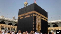 Jemaah umrah mengelilingi Ka'bah di Masjidil Haram, di kota suci Makkah, Arab Saudi, Minggu, 6 Maret 2022. Pemerintah Arab Saudi memutuskan untuk melonggarkan pembatasan terkait pandemi COVID-19,. (AP Photo/Amr Nabil)