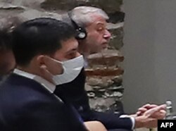 Oligarki Rusia Roman Abramovich (kanan) mendengarkan Presiden Turki saat ia berbicara kepada delegasi Rusia dan Ukraina pada pembukaan pembicaraan mereka di Istanbul, 29 Maret 2022. (Murat CETIN MUHURDAR / LAYANAN PERS PRESIDEN TURKI / AFP)