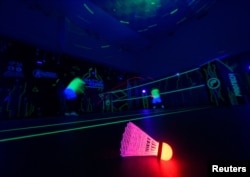 FILE - A badminton shuttlecock lit up in neon color at Shuttle in-the-dark badminton court in Kuala Lumpur, Malaysia, March 24, 2022. (REUTERS/Hasnoor Hussain)