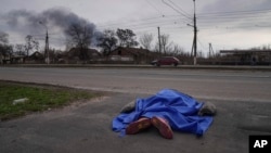 Telo poginulog leži pokriveno na ulici u Marijupolju