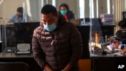 FILE - Juan Miranda, who is allegedly part of a human trafficking network, returns to his place after questioning in the courts of justice in Guatemala City, Feb. 4, 2022. 