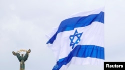 FILE - Bendera Israel yang ditempelkan pada drone (tidak terlihat) berkibar di samping Monumen Kemerdekaan dalam aksi yang diselenggarakan oleh aktivis pro-Israel di Kyiv, Ukraina, 14 Mei 2021. (REUTERS/Valentyn Ogirenko)