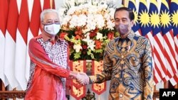 Presiden Indonesia Joko Widodo (kanan) berjabat tangan dengan Perdana Menteri Malaysia Ismail Sabri Yaakob dalam pertemuan mereka di Istana Kepresidenan RI di Jakarta, 1 April 2022. (Foto: Handout / ISTANA PRESIDEN RI/ AFP) 