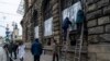 FILE - People cover the windows Museum of Ethnography with metal plates in Lviv, western Ukraine, March 2, 2022.