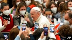 Pope Francis leaves at the end of an audience with members of the members of the Antoniano children's choir, at the Vatican, March 19, 2022.