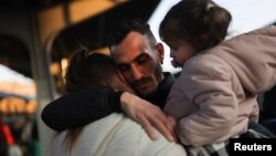 ជនភៀសខ្លួន​ម្នាក់​លា​ប្រពន្ធ​និងកូនស្រី​របស់​គាត់ មុន​នឹង​ពួកគេ​ឡើង​រថភ្លើង​ទៅ​កាន់​ទីក្រុង Budapest ដើម្បី​ភៀសខ្លួន​ពី​ការ​ឈ្លានពាន​របស់​រុស្ស៊ី​មក​លើ​អ៊ុយក្រែន នៅ​ទីក្រុង Bucharest ប្រទេស​រ៉ូម៉ានី ថ្ងៃទី១៤ ខែមីនា ឆ្នាំ២០២២។