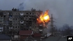 An explosion is seen in an apartment building in Mariupol, Ukraine, Friday, March 11, 2022. (AP Photo/Evgeniy Maloletka)