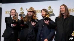 J.T. Cure, from left, Chris Stapleton, Dave Cobb, and Derek Mixon, winners of the award for best country song for "Cold," pose in the press room at the 64th Annual Grammy Awards at the MGM Grand Garden Arena on Sunday, April 3, 2022, in Las Vegas. (AP Pho