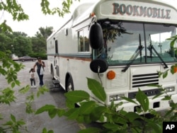 Isabelle Leach (lima tahun, kiri) dan ibunya, Azha Jose, datang ke Perpustakaan Negara Bagian New Mexico's Rural Bookmobile West di Ramah, New Mexico, Rabu, 2 September 2009. (AP/Heather Clark)