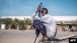 Seorang remaja di kamp pengungsi Hotel Agda tampak memegang botol air. Kamp tersebut terletak di Kota Semera, Afar, Ethiopia, pada 14 Februari 2022. (Foto: AFP/Eduardo Soteras)