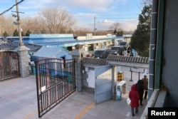 灵车在北京一家火葬场大门外排队。（2022年12月17日）