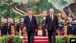 In this photo released by China's Xinhua News Agency, Chinese President Xi Jinping, left, and Cuba's President Miguel Diaz-Canel Bermudez walk during a welcome ceremony at the Great Hall of the People in Beijing, Friday, Nov. 25, 2022.
