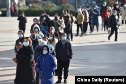 Residents line up outside a pharmacy to buy antigen testing kits for COVID-19 in Nanjing, Jiangsu province, China, Dec. 15, 2022.