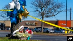 Flowers and balloons sit near the scene of a mass shooting at a Walmart, Nov. 23, 2022, in Chesapeake, Va. A Walmart manager opened fire on fellow employees in a break room of the Virginia store the night before.