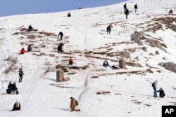 People play on a sunny day near the 2,334 m (7,657 ft) Hafelekar summit at the Nordkette Alps mountains in Innsbruck, Austria, Jan. 2, 2023.