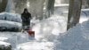 ARCHIVES - Un homme dégage un trottoir à l'aide d'une souffleuse dans le Bronx le 3 janvier 2014 à New York.