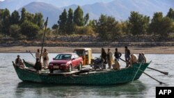 مردان افغان با استفاده از قایق‌ها موتر و یک ریکشا را در ولسوالی کوز ولایت ننگرهار (تصویر از آرشیف صدای امریکا)