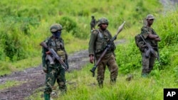 FILE - M23 rebels stand with theirs weapons in the town of Kibumba, in the eastern of Democratic Republic of Congo, Dec. 23, 2022.