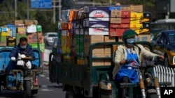 资料照：装满货物的车辆行驶在北京街头。 （2022年9月21日）