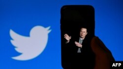 (FILES) Layar ponsel menampilkan foto Elon Musk dengan logo Twitter di Washington, DC., 4 Oktober 2022. (OLIVIER DOULIERY / AFP)