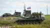 FILE - Recruits listen to an instructor standing atop of a tank during a military training at a firing range in the Rostov-on-Don region in southern Russia, Oct. 4, 2022.