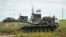 FILE - Recruits listen to an instructor standing atop of a tank during a military training at a firing range in the Rostov-on-Don region in southern Russia, Oct. 4, 2022.