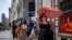 FILE - A woman holds an umbrella to shelter from the sun during a hot sunny day in Madrid, Spain, July 18, 2022. 