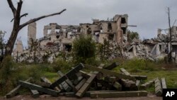 Ammunition boxes lie outside a destroyed school on the outskirts of a recently liberated village outskirts of Kherson, in southern Ukraine, Nov. 16, 2022. 