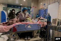 天津第一中心医院的医护人员在护理一名感染新冠的病人。（2022年12月28日）