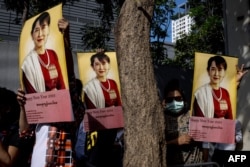 Para pengunjuk rasa membawa foto pemimpin sipil Myanmar Aung San Suu Kyi di luar Kedutaan Besar Myanmar di Bangkok pada 19 Desember 2022. (Foto: AFP)