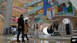 Shoppers walk through a reopened shopping mall after authorities started easing some of the COVID-19 restrictions in Beijing, Dec. 6, 2022.
