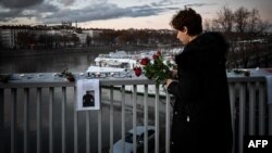 A local resident lays flowers during tribute to Mohammad Moradi, in Lyon on Dec. 27, 2022.