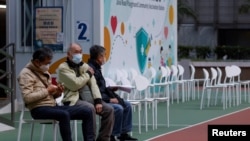 People sit at a community vaccination center ahead of an expected border reopening with China, during the COVID-19 pandemic in Hong Kong, Jan. 4, 2023.