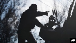 A Ukrainian soldier throws bullet casings from an armored vehicle near Bakhmut, Donetsk region, Ukraine, Dec. 22, 2022. 