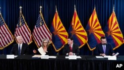 지난달 8일 치러진 중간선거에서 애리조나주 주지사 민주당 후보였던 케이티 홉스(사진 왼쪽에서 두 번째) 애리조나주 총무장관이 5일 중간선거 결과 인증서에 서명하고 있다.