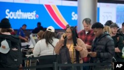 Travelers wade through the line for service at the Southwest Airlines check-in counter in Denver International Airport, Dec. 27, 2022.