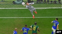 Le capitaine du Cameroun Vincent Aboubakar (maillot vert) devant le gardien de but du Brésil lors du match entre les Lions indomptables et la Seleçao au stade Lusail au Qatar, le 2 décembre 2022. 