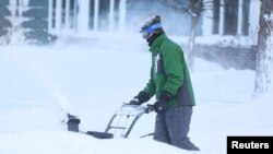 Mkazi wa mkoa wa Buffalo huko Amherst, New York akiondoa theluji katika njia ya kuingiza gari nyumbani kwake, Desemba 25, 2022.