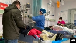 中国河北保定第二中心医院的医护人员正在护理病人。（2022年12月22日）