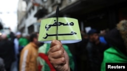 FILE - Algerian journalists demonstrate for freedom of the press, in Algiers, Algeria, Nov. 15, 2019. The armband reads "Free journalist." Algerian journalist Ihsane El-Kadi was detained Dec. 23, 2022, and appeared in an Algiers court on Dec. 29, 2022.