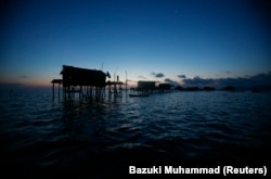 Sebuah pemukiman masyarakat Bajau Laut terlihat saat matahari terbenam di Laut Sulawesi, 17 Februari 2009. (Foto: REUTERS/Bazuki Muhammad)